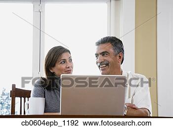 Stock Photo - middle-aged couple 
using laptop. 
fotosearch - search 
stock photos, 
pictures, images, 
and photo clipart