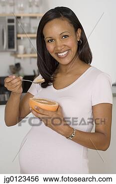 Stock Photo - pregnant african 
woman eating grapefruit. 
fotosearch - search 
stock photos, 
pictures, images, 
and photo clipart