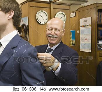 Stock Image - senior hispanic 
male tailor fitting 
man for suit. 
fotosearch - search 
stock photos, 
pictures, images, 
and photo clipart