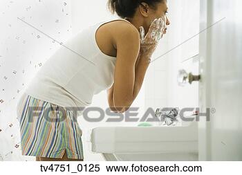 Stock Image - african woman 
washing face in 
bathroom sink. 
fotosearch - search 
stock photos, 
pictures, images, 
and photo clipart