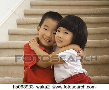 Stock Photo - asian brother 
and sister hugging 
on stairs. fotosearch 
- search stock 
photos, pictures, 
images, and photo 
clipart