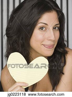 Stock Photo - hispanic woman 
holding cut out 
paper heart. fotosearch 
- search stock 
photos, pictures, 
images, and photo 
clipart