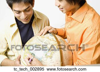 Stock Image - two young men 
looking at globe. 
fotosearch - search 
stock photos, 
pictures, images, 
and photo clipart