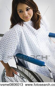 Stock Photo - young hispanic 
woman wearing 
hospital gown 
in wheelchair. 
fotosearch - search 
stock photos, 
pictures, images, 
and photo clipart