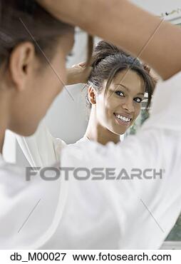Picture - african woman 
fixing her hair 
in mirror. fotosearch 
- search stock 
photos, pictures, 
images, and photo 
clipart