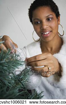 Stock Photography - african woman 
putting ornament 
on christmas tree. 
fotosearch - search 
stock photos, 
pictures, images, 
and photo clipart