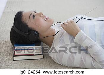 Stock Photo - asian woman listening 
to headphones 
on floor. fotosearch 
- search stock 
photos, pictures, 
images, and photo 
clipart