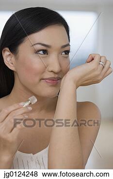 Stock Photo - asian woman smelling 
perfume on wrist. 
fotosearch - search 
stock photos, 
pictures, images, 
and photo clipart