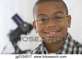 Picture - close up of african 
boy with microscope 
in background. 
fotosearch - search 
stock photos, 
pictures, images, 
and photo clipart