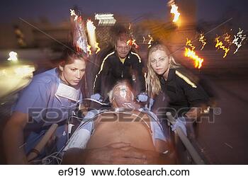 Stock Photograph - doctors wheeling 
emergency patient 
on gurney outdoors 
at night. fotosearch 
- search stock 
photos, pictures, 
images, and photo 
clipart