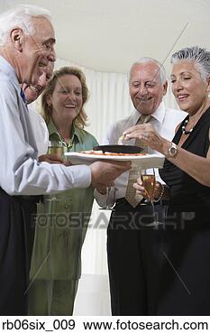 Stock Photograph - group of seniors 
at party eating 
hors d’oeuvres. 
fotosearch - search 
stock photos, 
pictures, images, 
and photo clipart