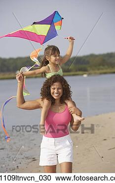 Stock Photography - hispanic mother 
and daughter flying 
kite on beach. 
fotosearch - search 
stock photos, 
pictures, images, 
and photo clipart