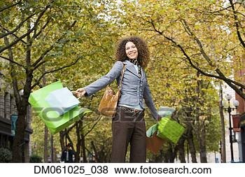 Stock Photo - hispanic woman 
swinging shopping 
bags in urban 
park. fotosearch 
- search stock 
photos, pictures, 
images, and photo 
clipart