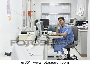 Stock Photography - indian male nurse 
sitting at computer 
in medical office. 
fotosearch - search 
stock photos, 
pictures, images, 
and photo clipart