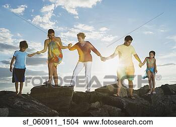 Stock Photo - low angle view 
of hispanic family 
holding hands 
on rocks. fotosearch 
- search stock 
photos, pictures, 
images, and photo 
clipart