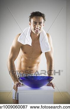 Picture - man with towel 
around neck next 
to wash basin. 
fotosearch - search 
stock photos, 
pictures, images, 
and photo clipart