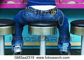 Stock Photograph - rear view of young 
person with studded 
belt sitting on 
stool at. fotosearch 
- search stock 
photos, pictures, 
images, and photo 
clipart