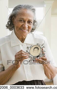 Stock Photo - senior african 
woman holding 
old baby photograph. 
fotosearch - search 
stock photos, 
pictures, images, 
and photo clipart
