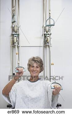 Stock Photograph - senior female 
patient performing 
physical therapy 
in hospital gown. 
fotosearch - search 
stock photos, 
pictures, images, 
and photo clipart