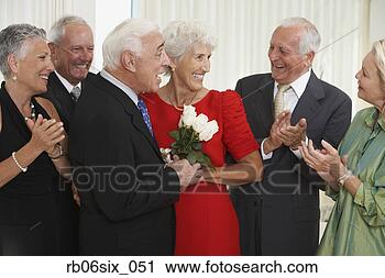 Stock Photography - senior man giving 
wife bouquet of 
flowers while 
friends clap. 
fotosearch - search 
stock photos, 
pictures, images, 
and photo clipart