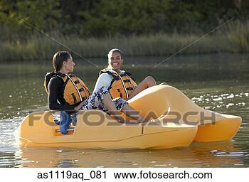Stock Photography - two african women 
in paddle boat. 
fotosearch - search 
stock photos, 
pictures, images, 
and photo clipart