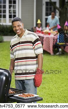 Picture - african father 
barbequing for 
child’s birthday. 
fotosearch - search 
stock photos, 
pictures, images, 
and photo clipart