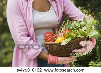Stock Photo - african woman 
carrying basket 
of fresh vegetables. 
fotosearch - search 
stock photos, 
pictures, images, 
and photo clipart
