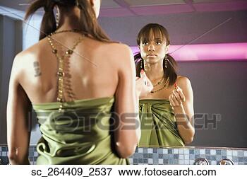 Picture - african woman 
holding lipstick 
and looking in 
mirror. fotosearch 
- search stock 
photos, pictures, 
images, and photo 
clipart