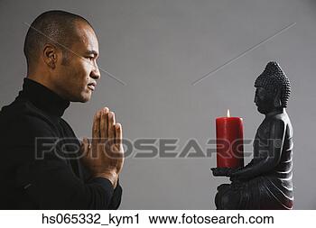Stock Photography - asian man meditating 
in front of buddha 
statue. fotosearch 
- search stock 
photos, pictures, 
images, and photo 
clipart