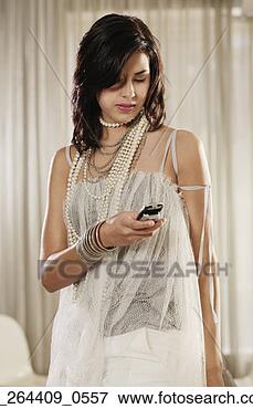 Picture - fashionably dress 
hispanic woman 
looking at cell 
phone. fotosearch 
- search stock 
photos, pictures, 
images, and photo 
clipart