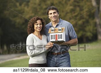 Stock Photo - hispanic couple 
holding model 
of house. fotosearch 
- search stock 
photos, pictures, 
images, and photo 
clipart