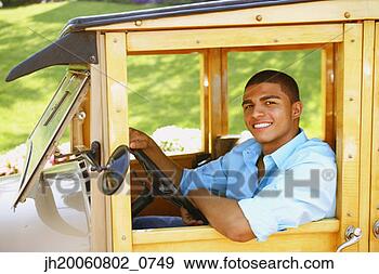 Stock Photograph - hispanic man driving 
old fashioned 
car. fotosearch 
- search stock 
photos, pictures, 
images, and photo 
clipart