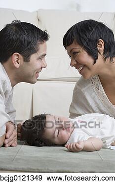 Stock Photograph - hispanic parents 
smiling over sleeping 
baby. fotosearch 
- search stock 
photos, pictures, 
images, and photo 
clipart