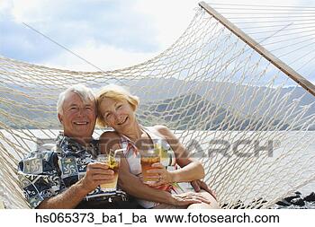 Stock Photography - senior couple 
in hammock holding 
drinks. fotosearch 
- search stock 
photos, pictures, 
images, and photo 
clipart
