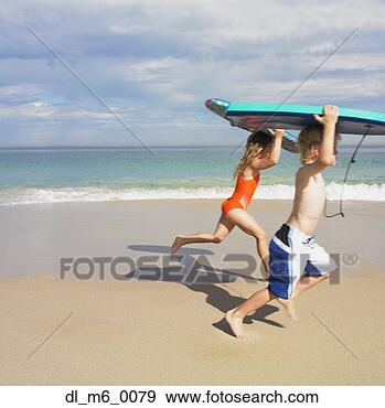 Stock Photograph - sister and brother 
running with boogie 
boards at beach. 
fotosearch - search 
stock photos, 
pictures, images, 
and photo clipart