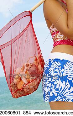 Stock Photo - woman carrying 
net full of seashells. 
fotosearch - search 
stock photos, 
pictures, images, 
and photo clipart