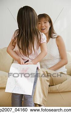 Stock Photography - asian girl surprising 
mother with drawing. 
fotosearch - search 
stock photos, 
pictures, images, 
and photo clipart