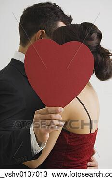 Stock Photo - hispanic couple 
hugging behind 
cut out heart. 
fotosearch - search 
stock photos, 
pictures, images, 
and photo clipart