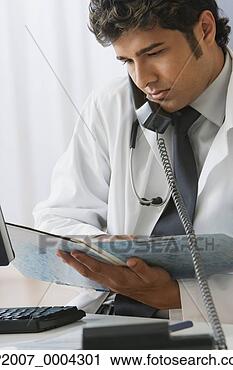 Stock Photography - indian male doctor 
looking at medical 
records. fotosearch 
- search stock 
photos, pictures, 
images, and photo 
clipart