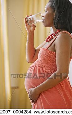 Stock Photo - pregnant african 
woman drinking 
water. fotosearch 
- search stock 
photos, pictures, 
images, and photo 
clipart