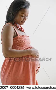 Stock Image - pregnant african 
woman looking 
at belly. fotosearch 
- search stock 
photos, pictures, 
images, and photo 
clipart