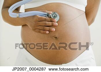 Picture - pregnant african 
woman holding 
stethoscope on 
belly. fotosearch 
- search stock 
photos, pictures, 
images, and photo 
clipart