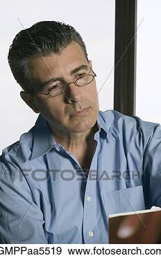 Stock Photograph - studio shot of 
hispanic middle-aged 
man reading. fotosearch 
- search stock 
photos, pictures, 
images, and photo 
clipart