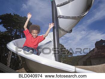 Stock Photo - african american 
boy playing on 
slide. fotosearch 
- search stock 
photos, pictures, 
images, and photo 
clipart