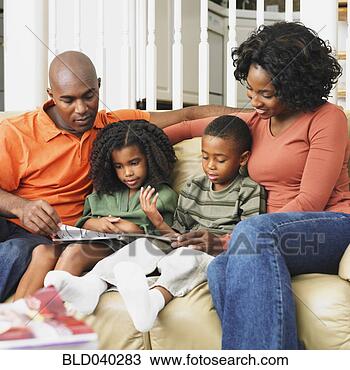 Stock Photo - african american 
family reading 
on sofa. fotosearch 
- search stock 
photos, pictures, 
images, and photo 
clipart