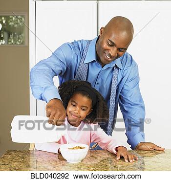 Stock Photo - african american 
father pouring 
milk into daughter’s 
cereal. fotosearch 
- search stock 
photos, pictures, 
images, and photo 
clipart