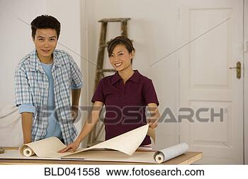 Stock Photo - asian couple hanging 
wall paper. fotosearch 
- search stock 
photos, pictures, 
images, and photo 
clipart