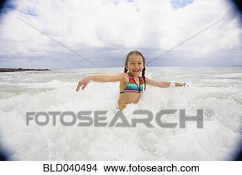 Stock Photo - asian girl playing 
in surf. fotosearch 
- search stock 
photos, pictures, 
images, and photo 
clipart