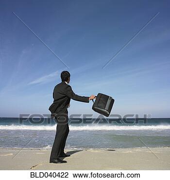 Stock Photo - hispanic businessman 
throwing briefcase 
at beach. fotosearch 
- search stock 
photos, pictures, 
images, and photo 
clipart