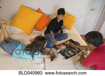 Stock Photo - hispanic father 
and children playing 
board game. fotosearch 
- search stock 
photos, pictures, 
images, and photo 
clipart